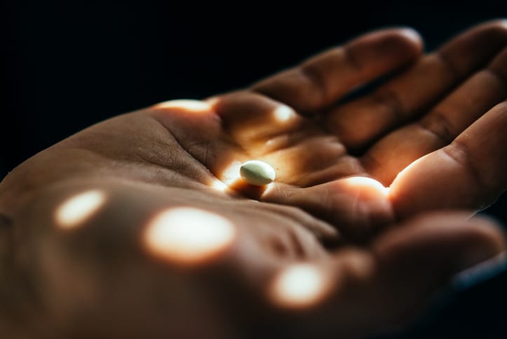Photo shows a hand with a pill in it/Getty Images
