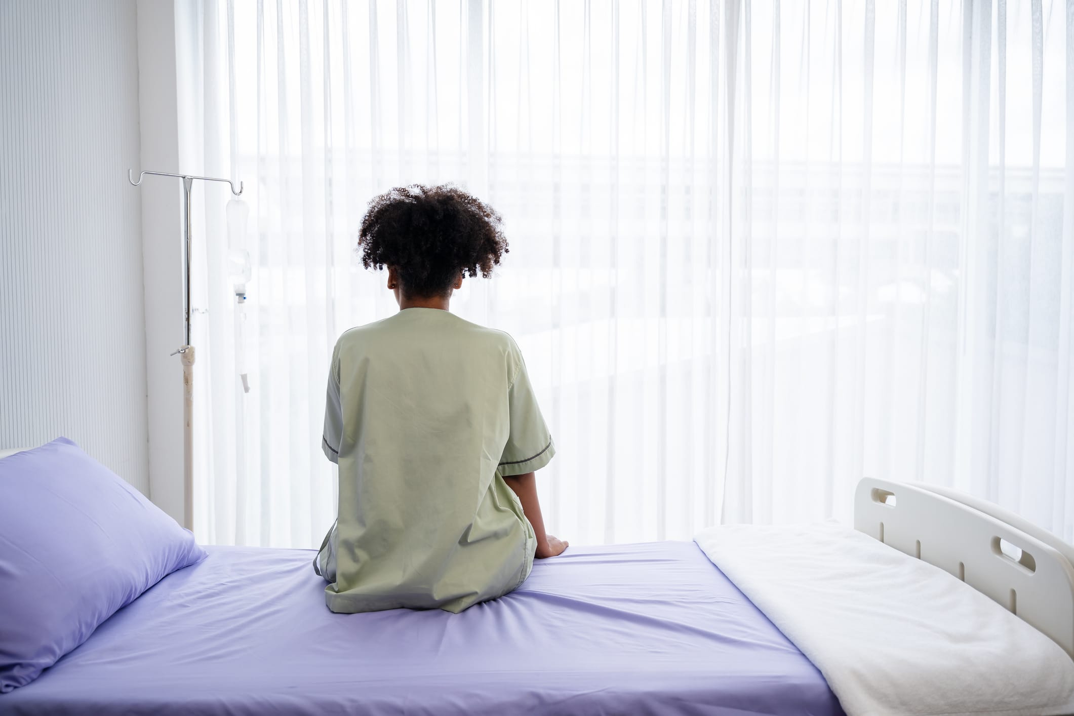 Black woman sitting on hospital bed
