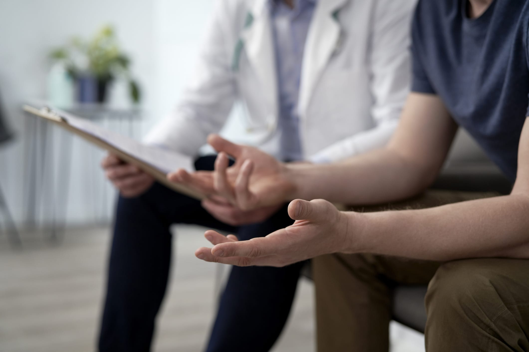 Man gesturing and discussing with doctor at clinic