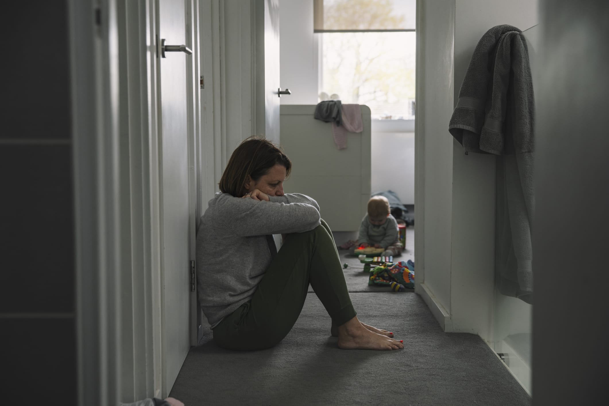 Woman sitting on floor with a child in the background