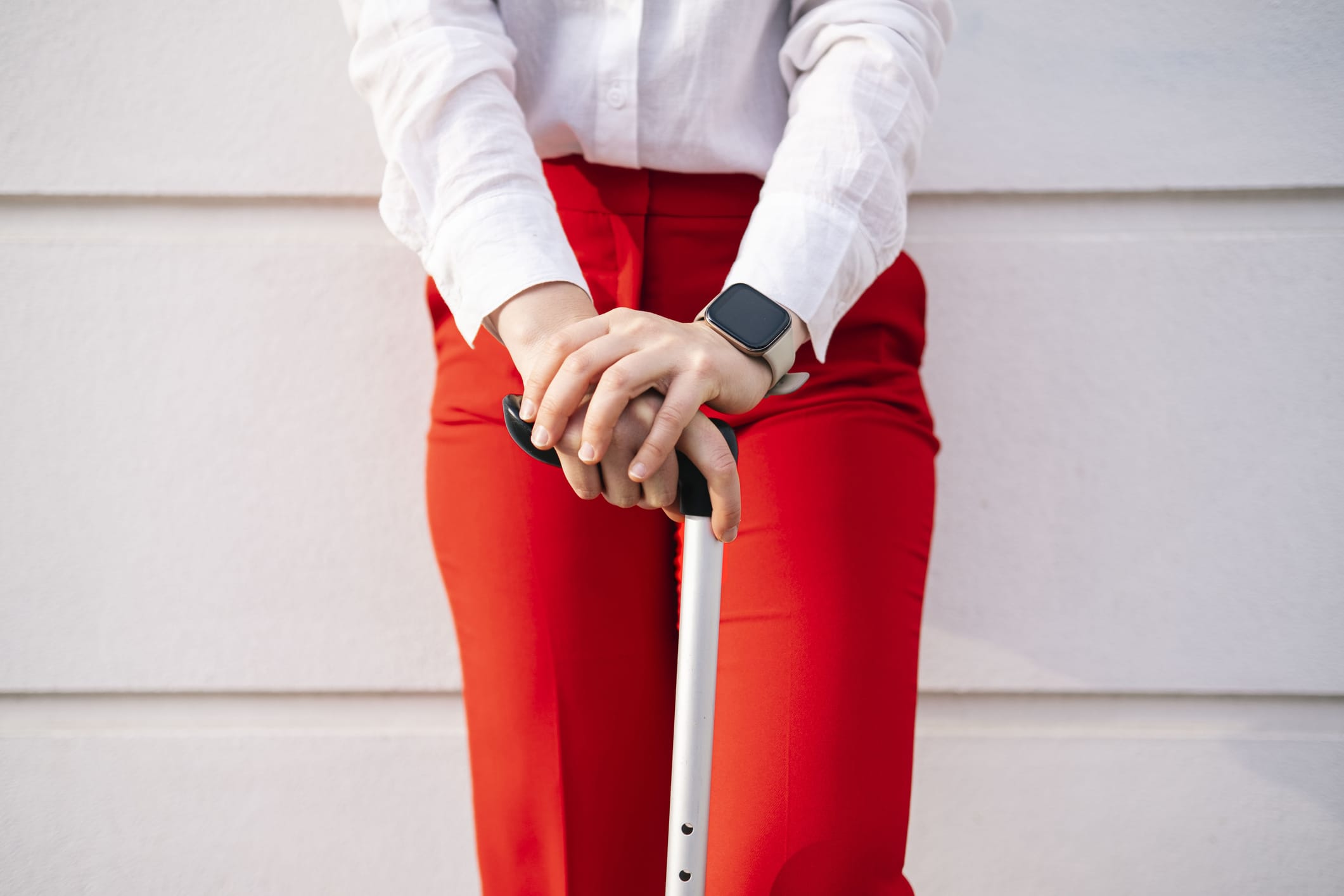Woman holding walking cane in front of wall