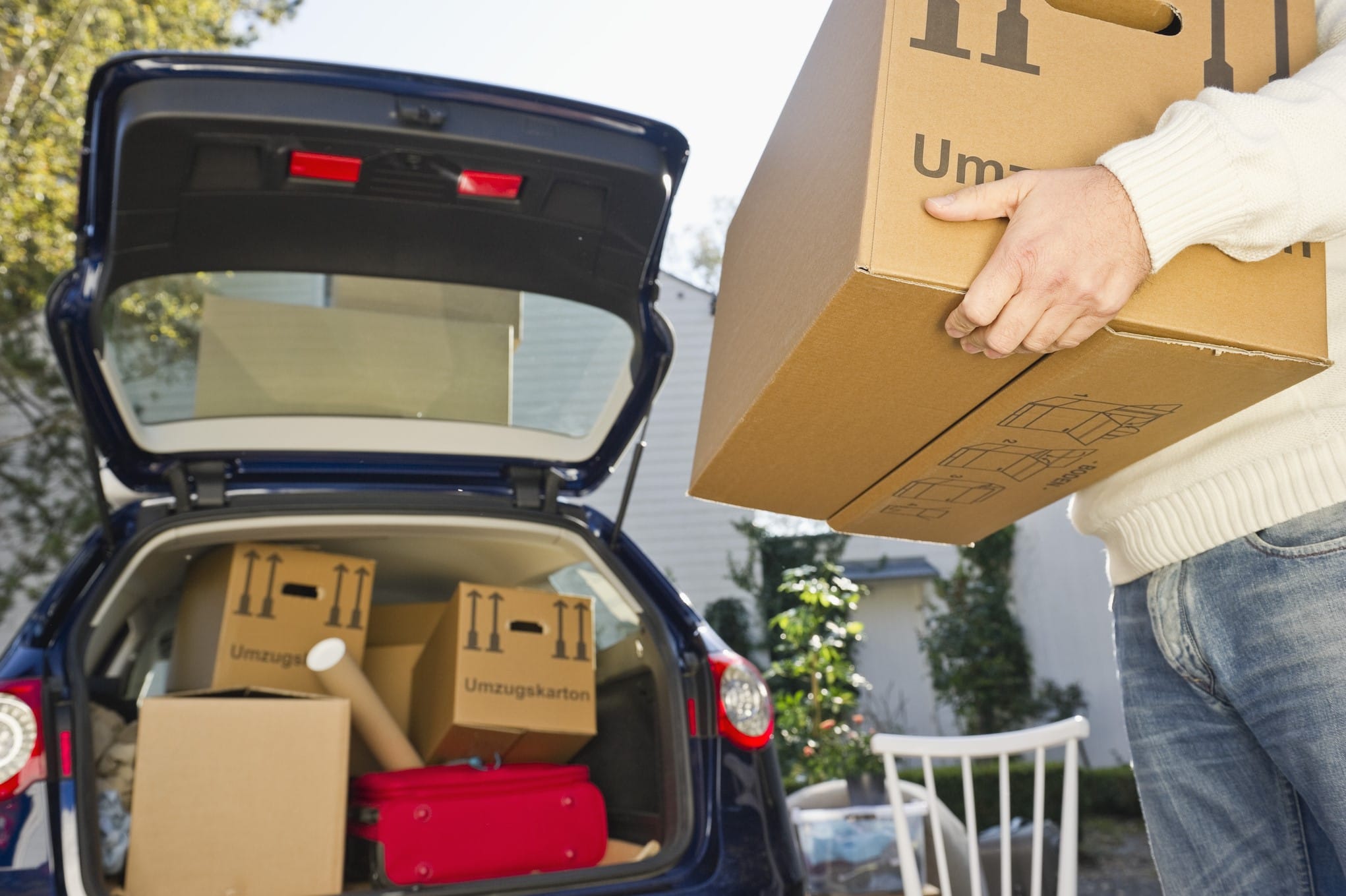 Man moving boxes into the back of a car