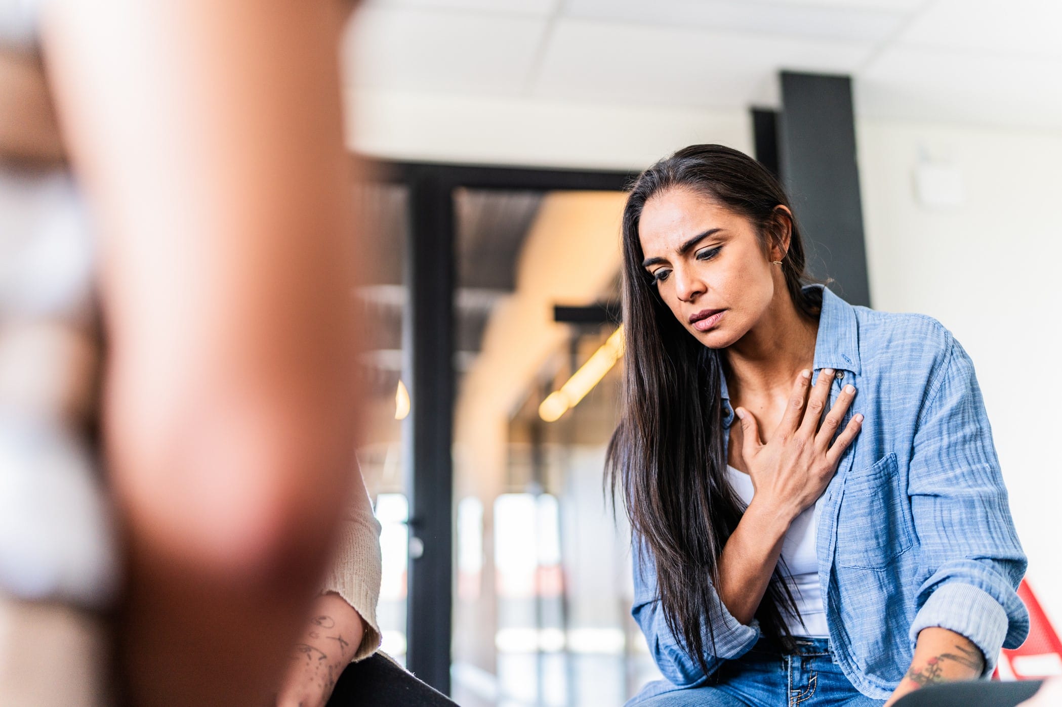 Woman having trouble breathing holding hand to chest