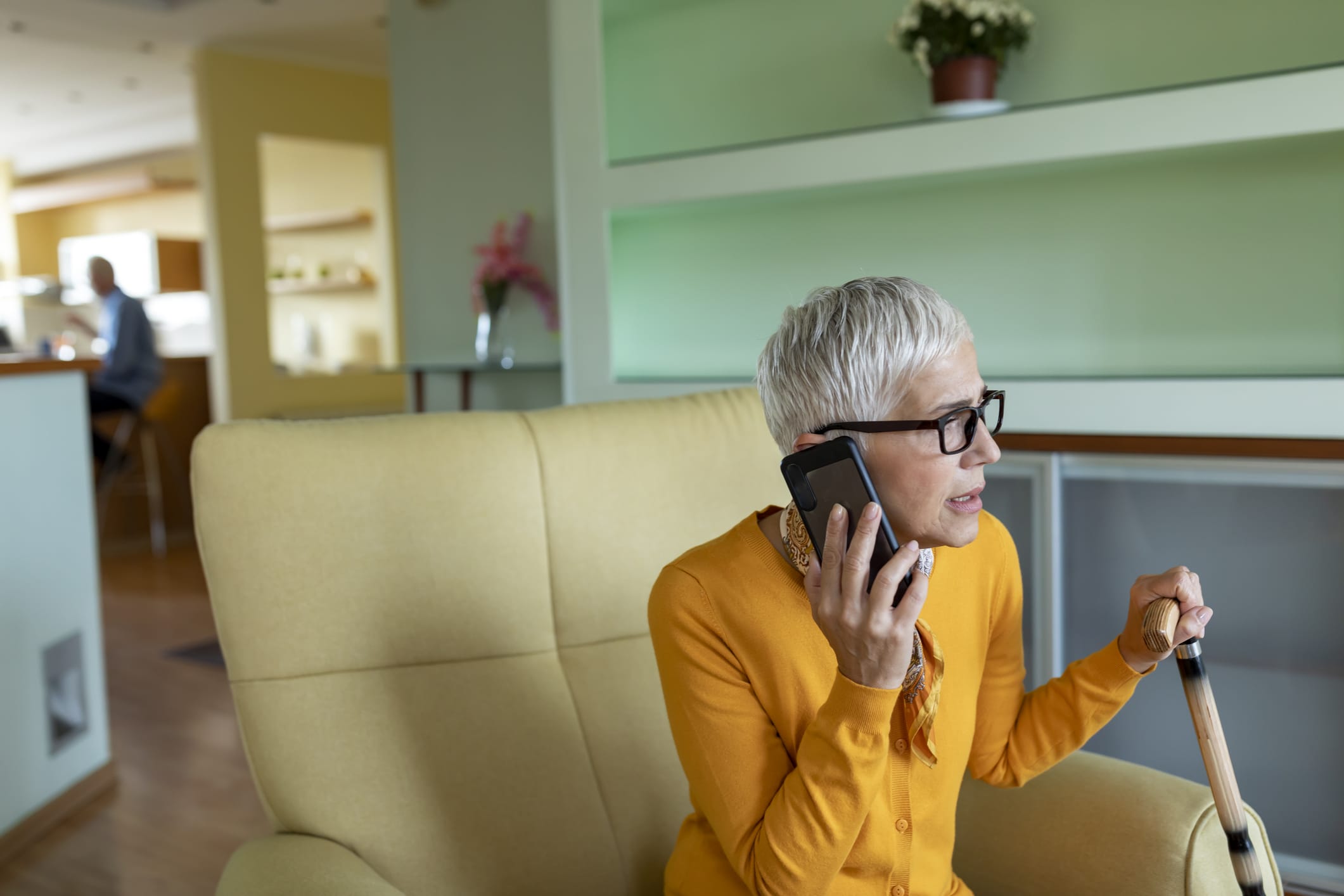 Woman holding cane and she talks on cell phone